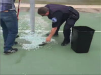 Officer Jerry Baskette cleans a basketball court with a citizen
