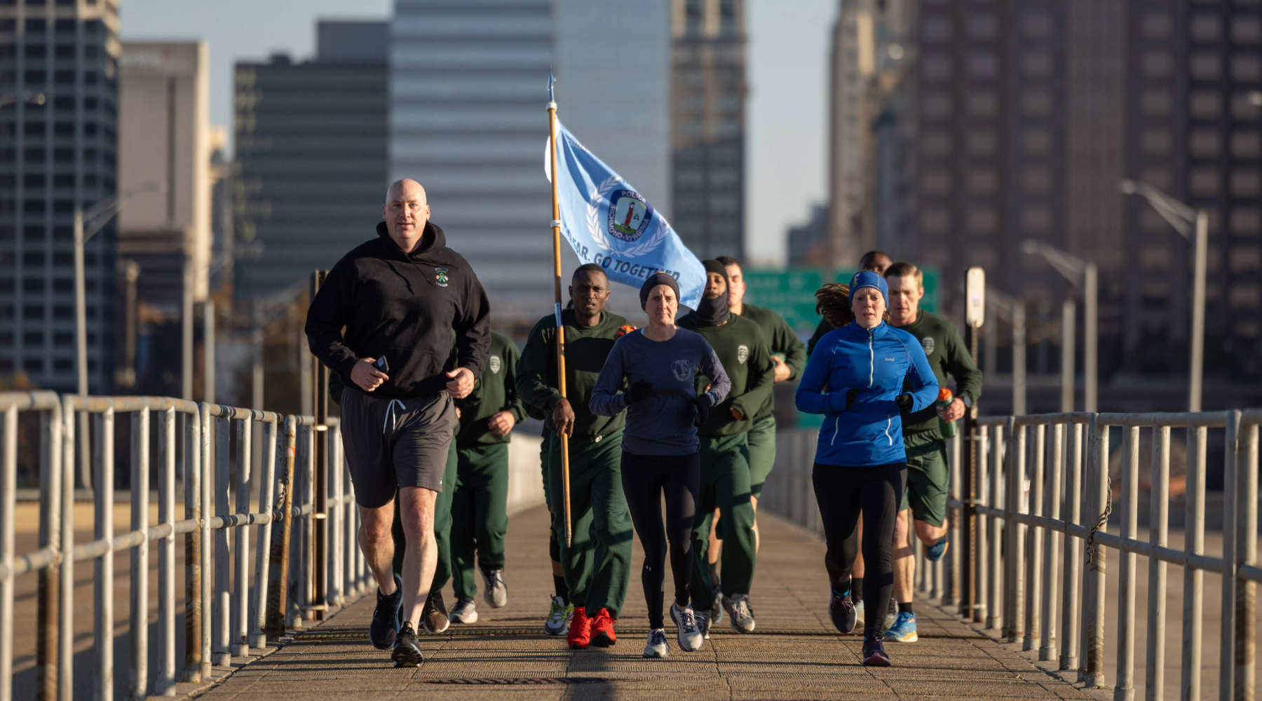 Chief Edwards and police run in downtown Richmond carrying an RPD flag.
