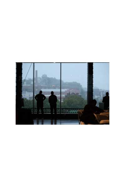 Two people in shadow stand in front of a window at Main Street Station looking at the Richmond skyline.